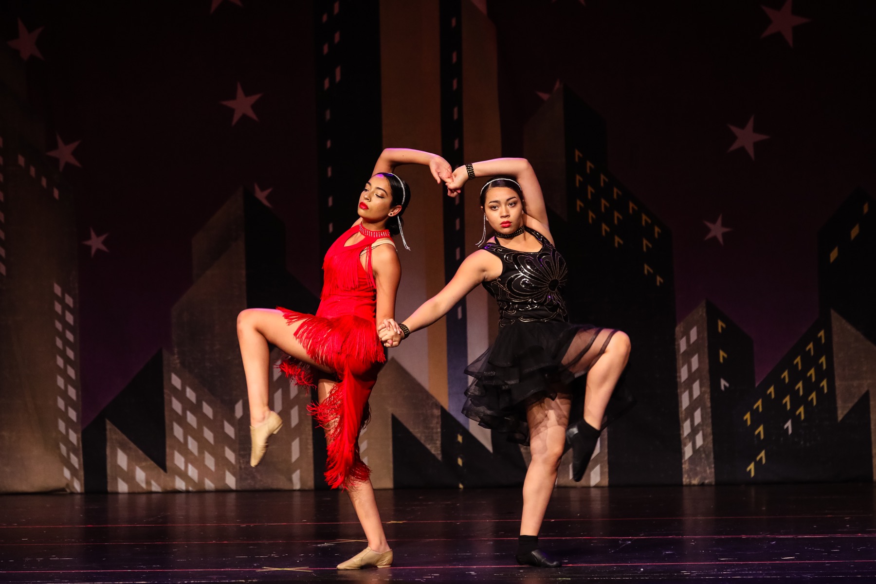 Two dancers performing an energetic duet on stage
